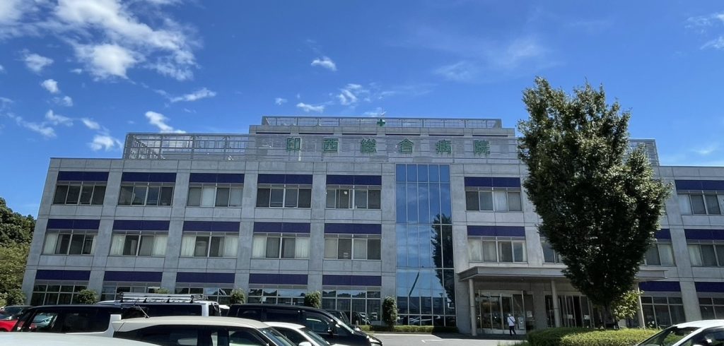 介護施設の建物外観。3階建てモダン設計の施設で、駐車場と入口が見える。